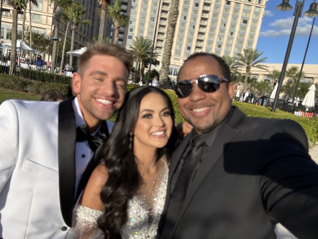 Wayde sharing a celebratory selfie with newlyweds outdoors