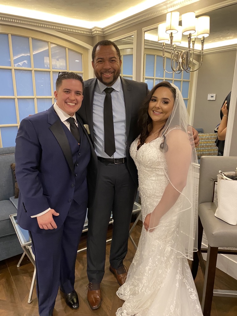 Wayde with a newly married couple in an elegant bridal suite
