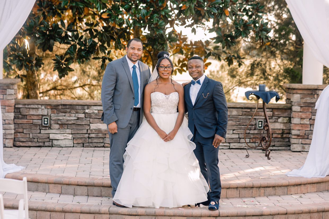 Wayde posing with a couple after their outdoor ceremony