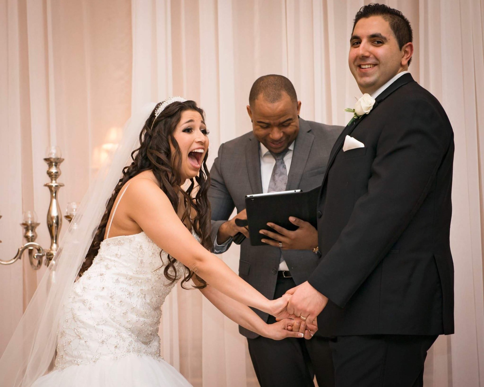A couple laughing with Wayde during their ceremony